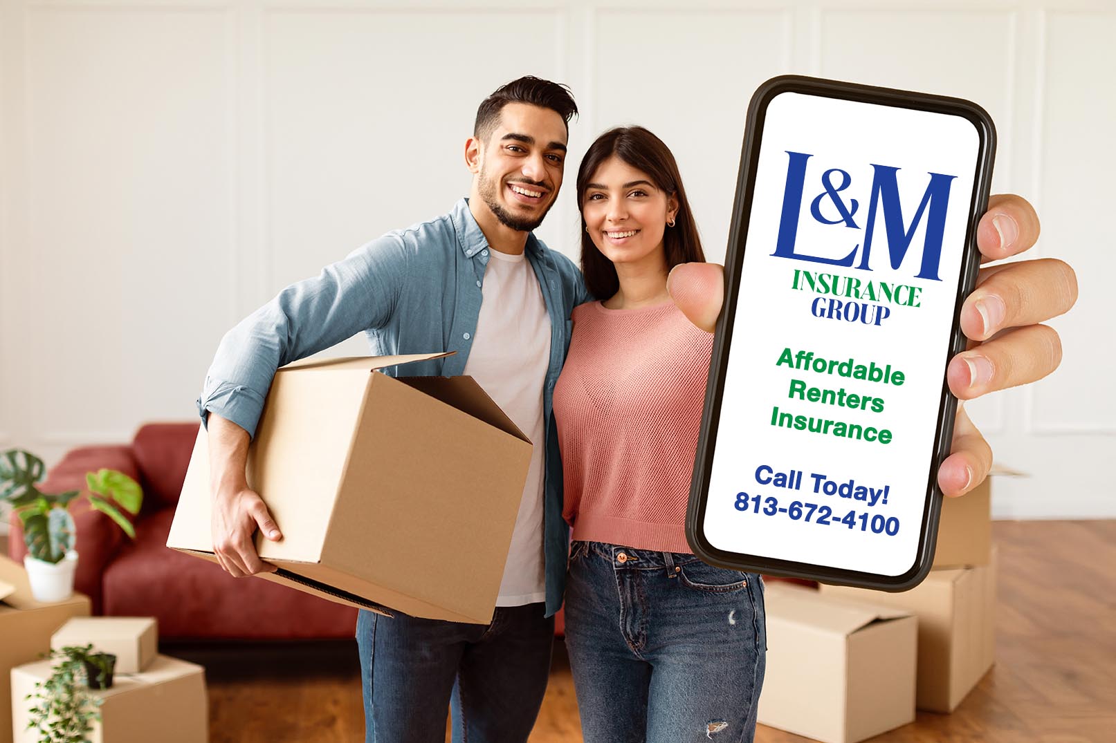 Home Rental. Young Couple Showing Keys And Holding Cardboard Box, Cheerful Guy And Lady Hugging After Moving In New Apartment Standing In Living Room. Home or Rental Insurance,